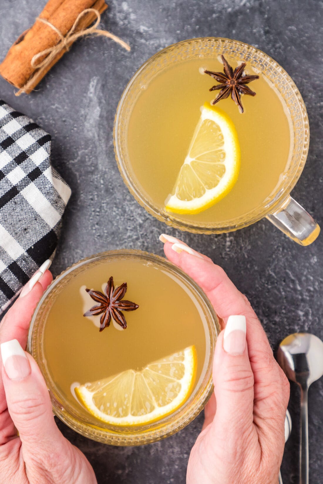 Hands holding a Hot Toddy next to another Hot Toddy