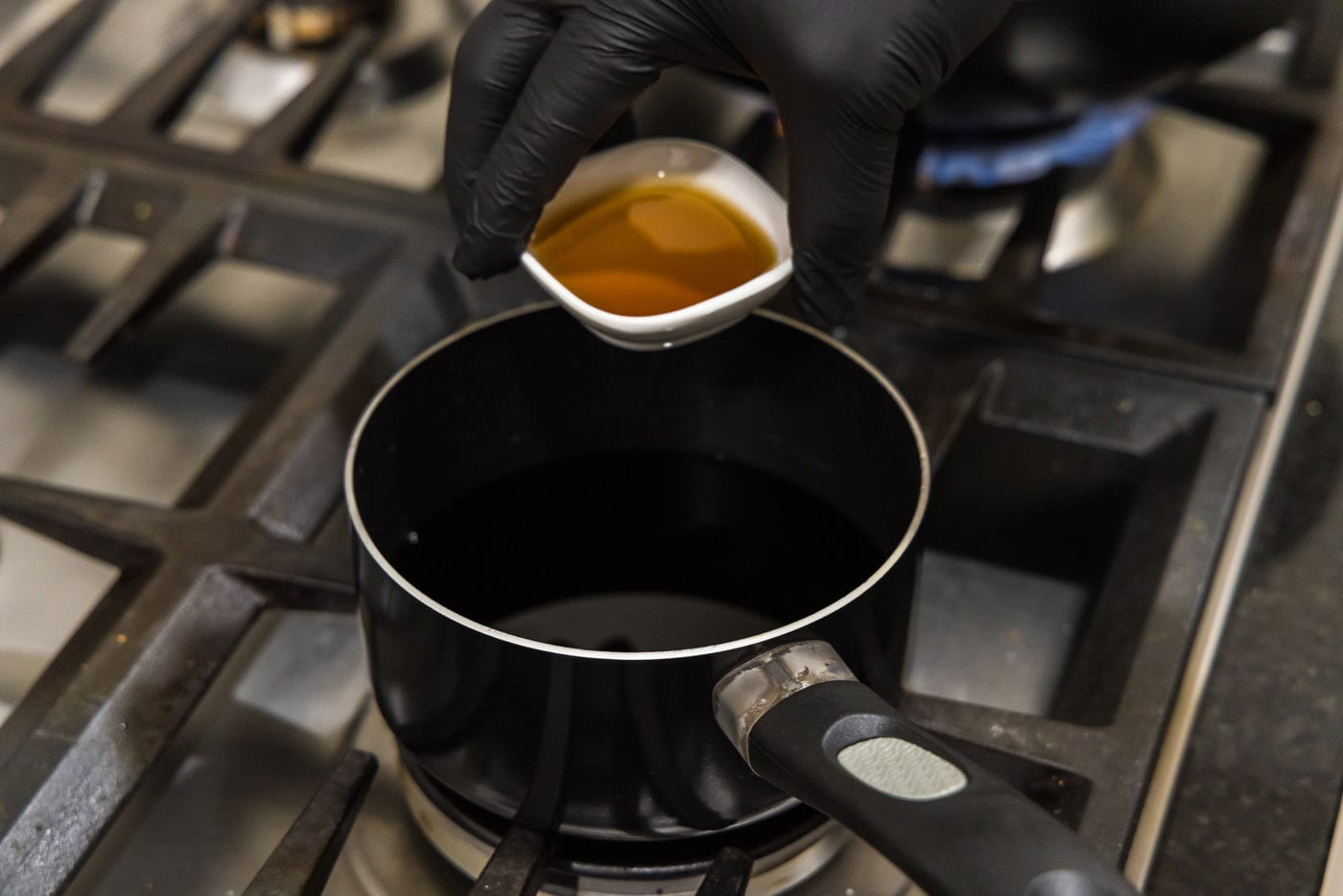 pouring sesame oil into saucepan