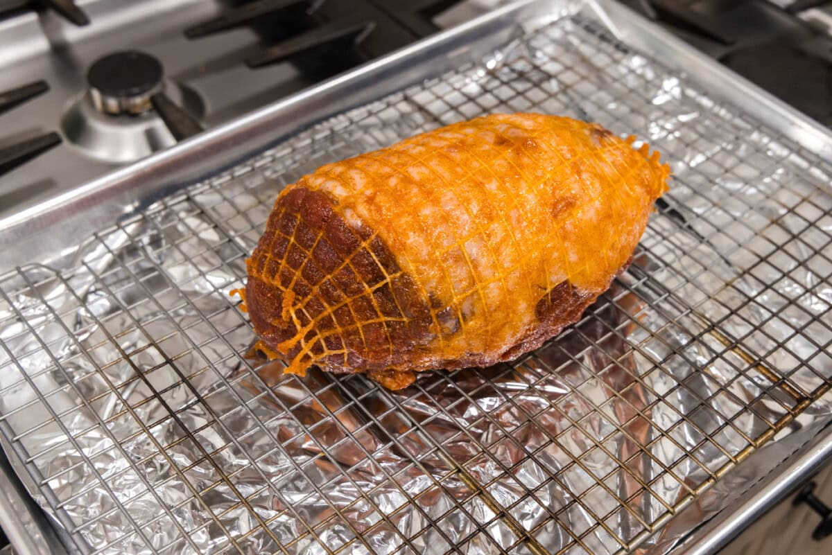 leg of lamb on a wire rack over a baking sheet