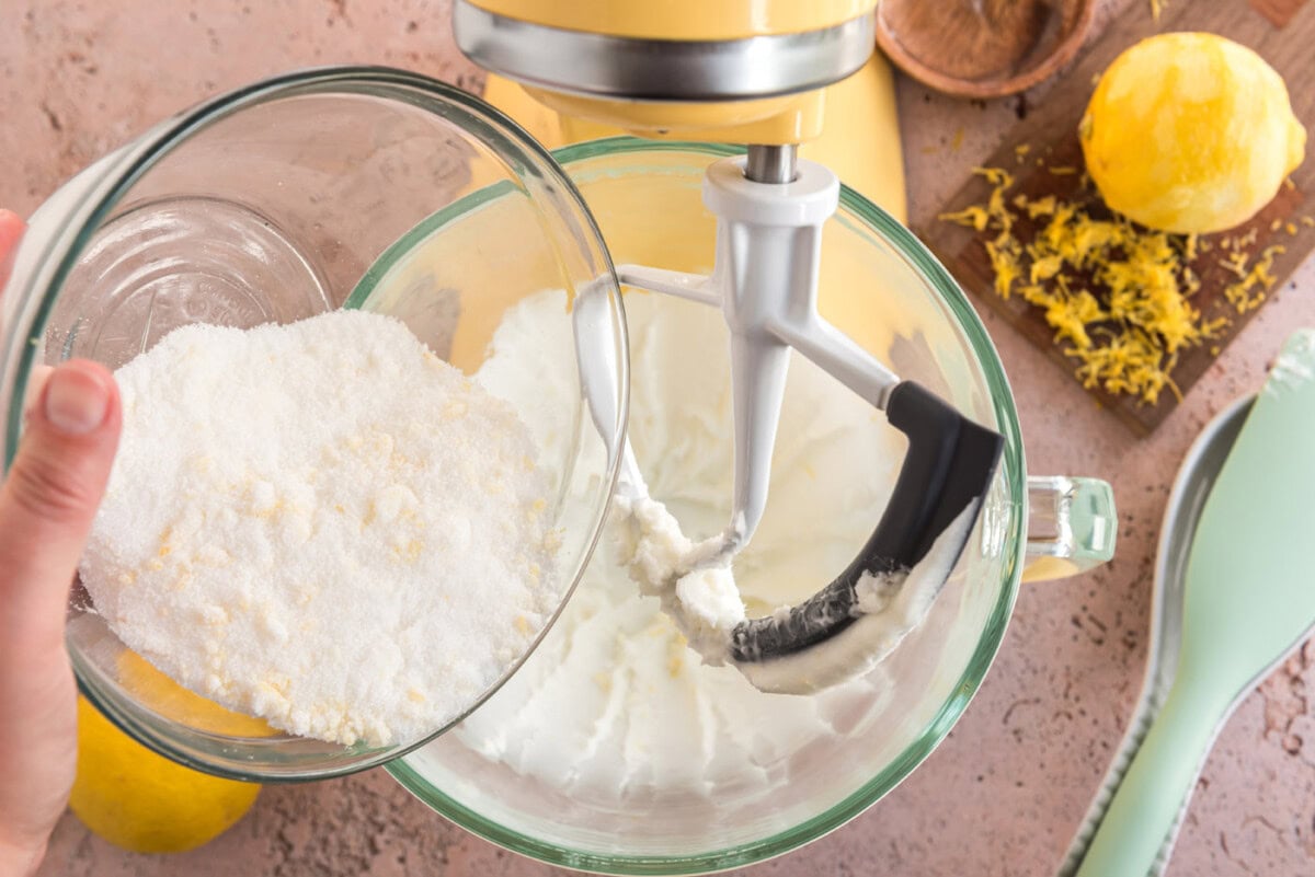 adding sugar and zest to mixer with dry ingredients