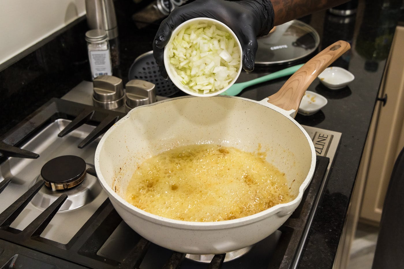 adding onion, garlic, and ginger to pan of melted butter