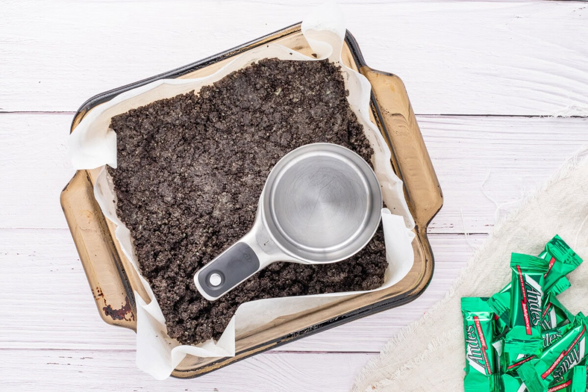 pressing Oreo crumbs into bottom of a baking pan