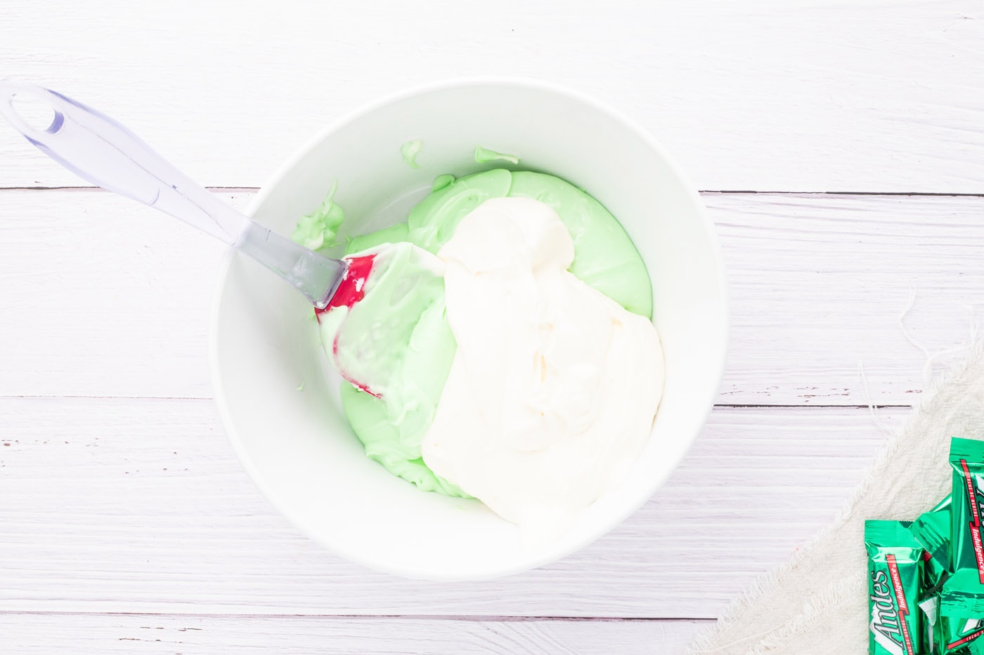folding thickened whipped cream into peppermint cream cheese mixture