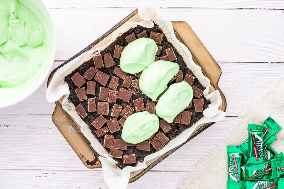 adding dollops of peppermint cream cheese on top of Oreo cookies and Andes mints