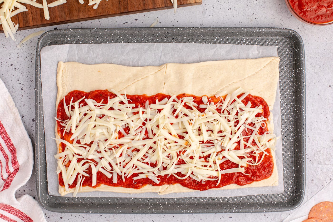 mozzarella cheese on top of pizza sauce and crescent dough