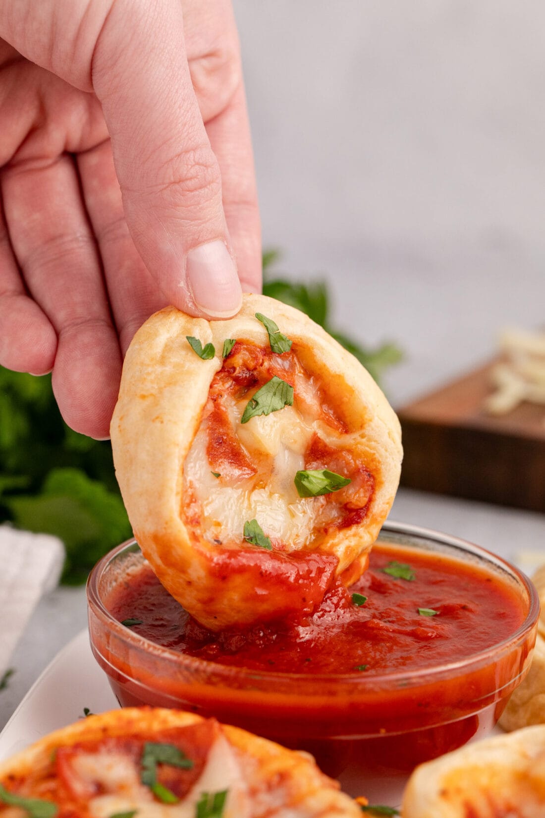 Pizza Pinwheel being dipped into pizza sauce