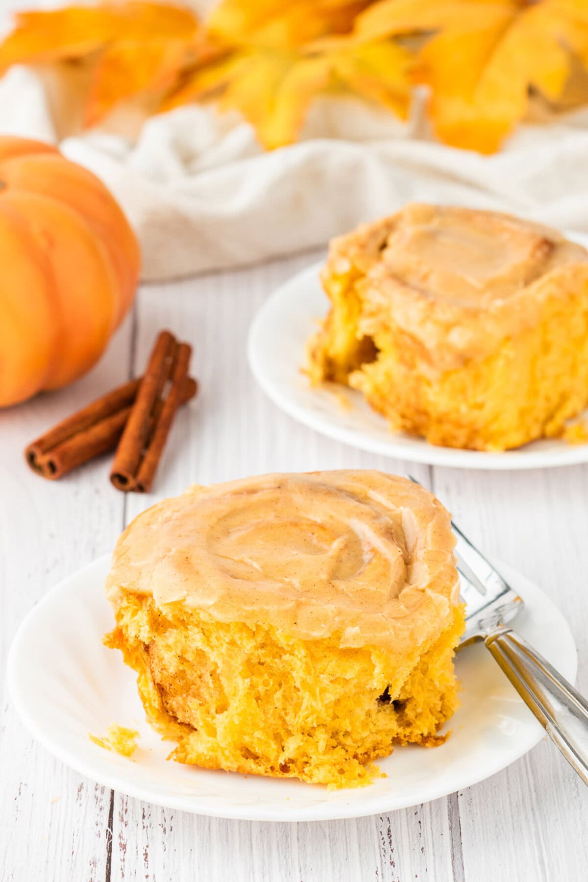 Two Pumpkin Cinnamon Rolls on plates