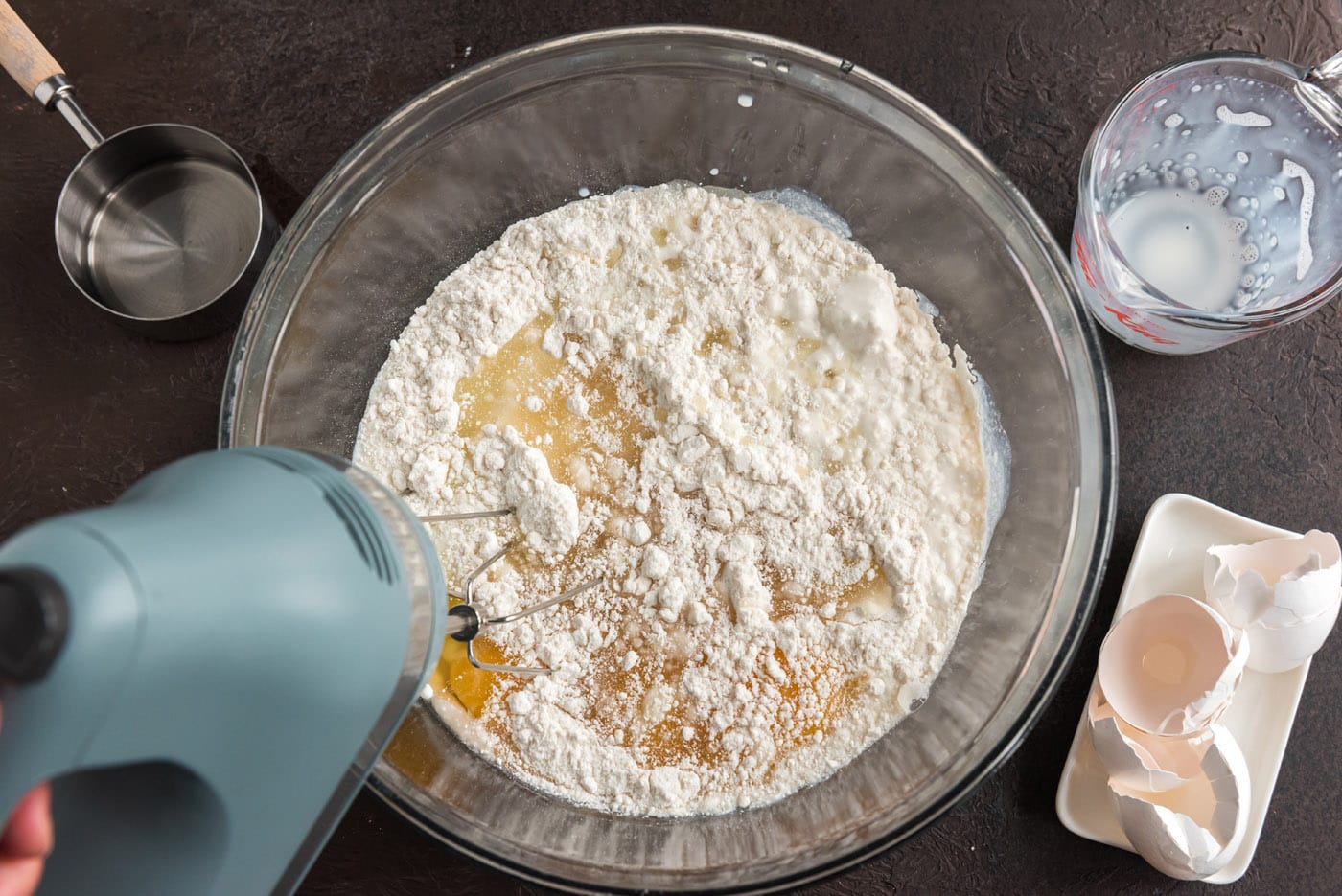 beating cake batter ingredients in a mixing bowl