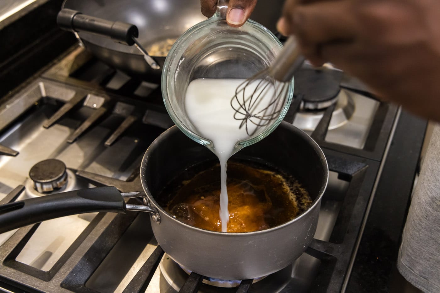 pouring cornstarch slurry to stir fry sauce in pan