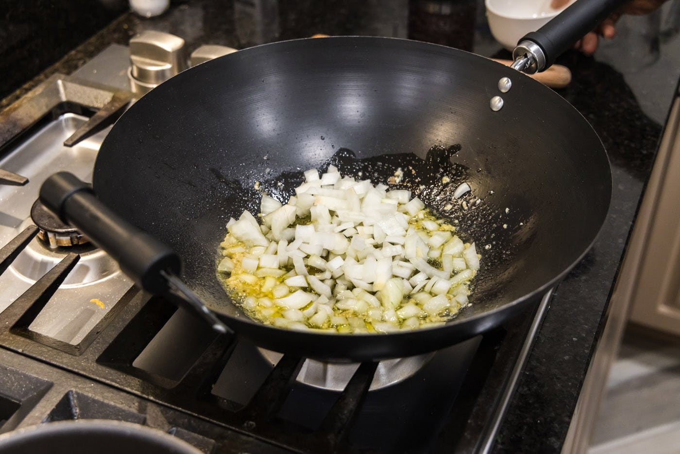 sauteeing onion in a wok