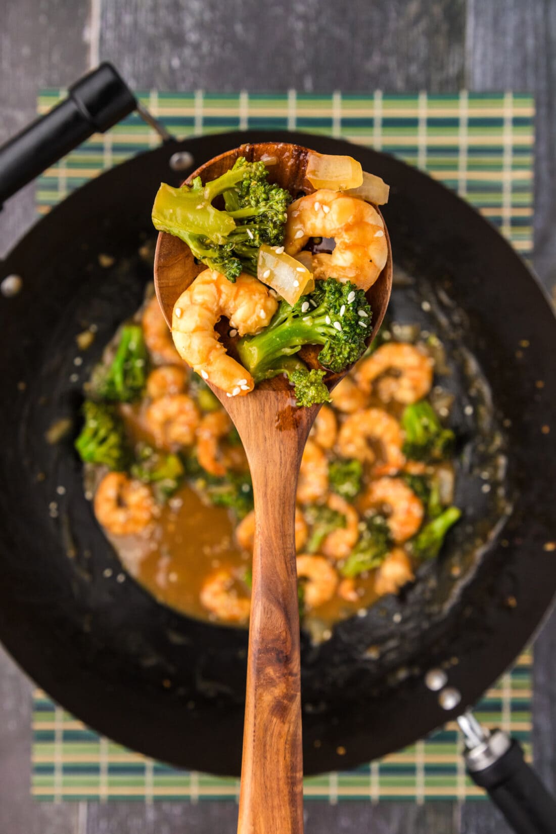 Spoon of Shrimp and Broccoli held above a wok of Shrimp and Broccoli