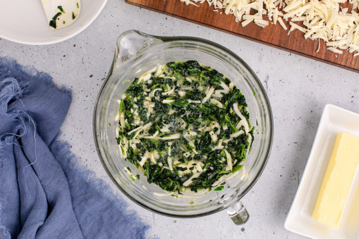 mixed spinach souffle ingredients in a bowl