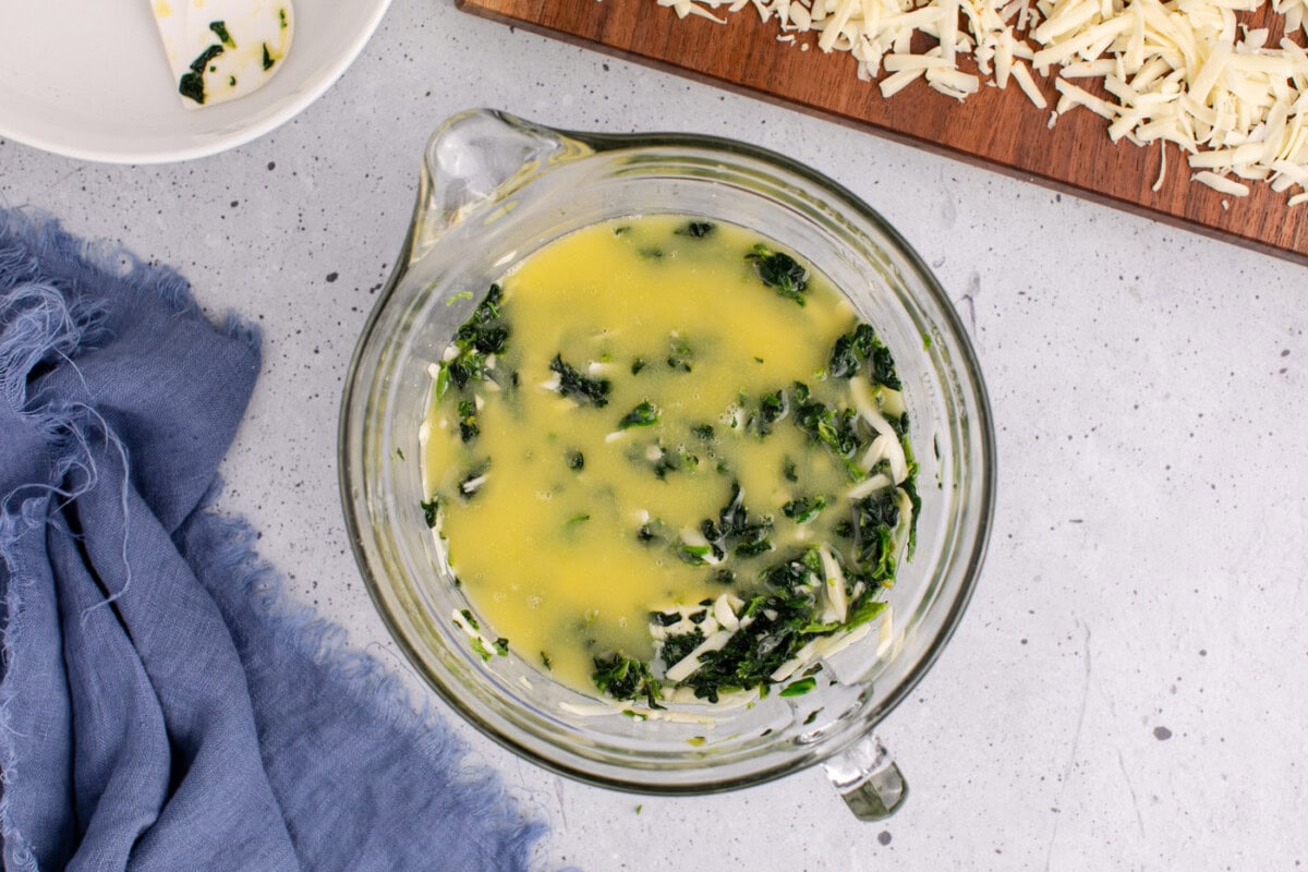 melted butter on top of spinach souffle mixture