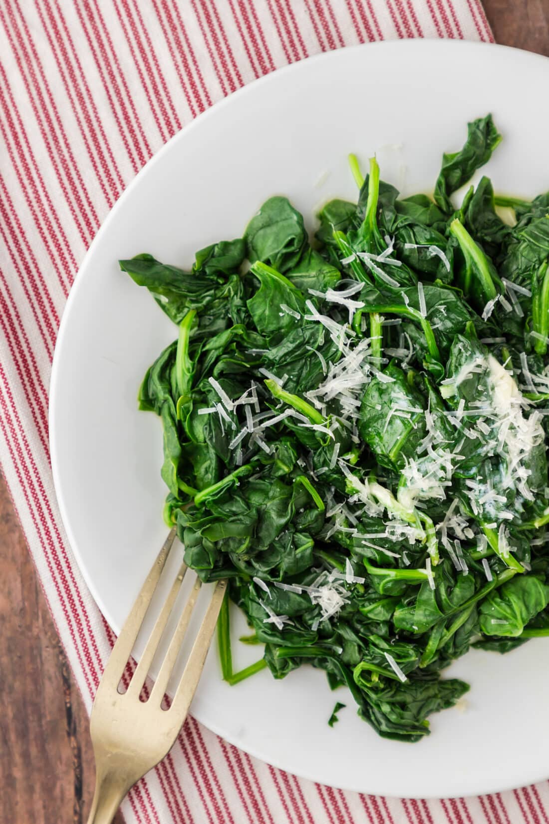 Close up photo of a plate of Steamed Spinach with a fork