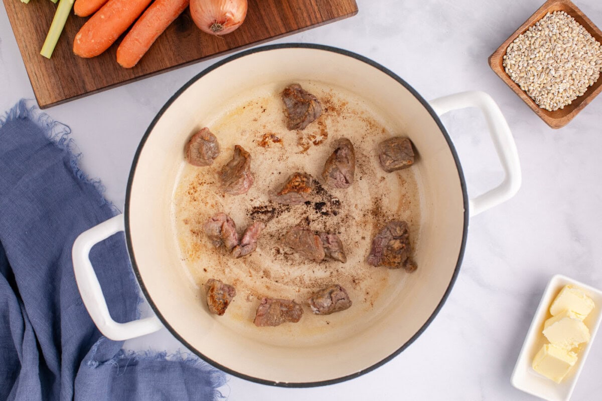 searing stew meat in a pot with butter