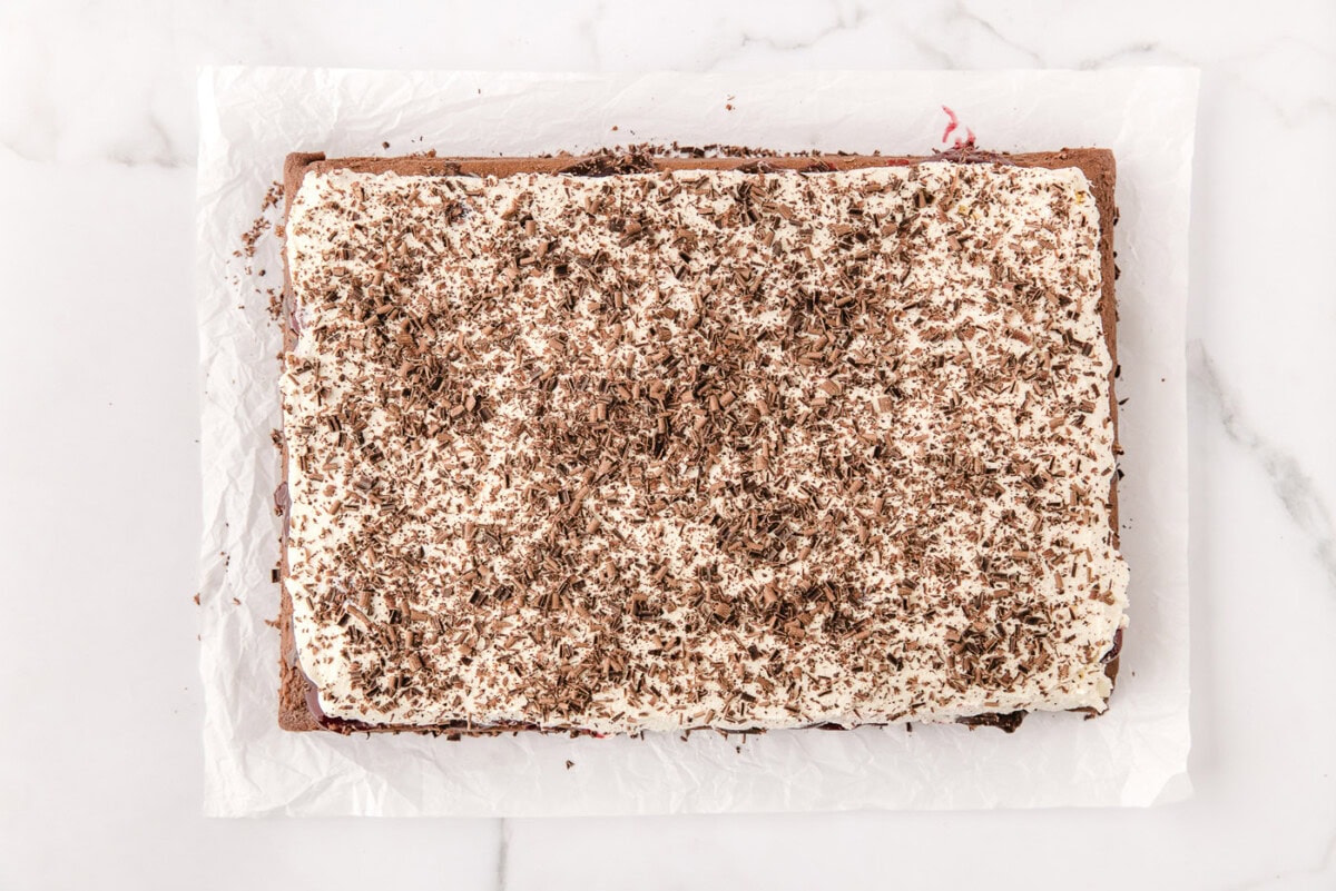 chocolate shavings on top of whipped cream over black forest poke cake