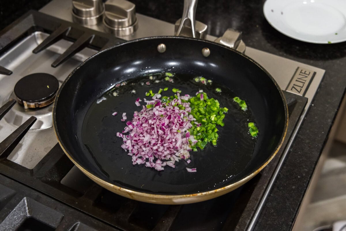 chopped onion and jalapeno peppers in a skillet with oil