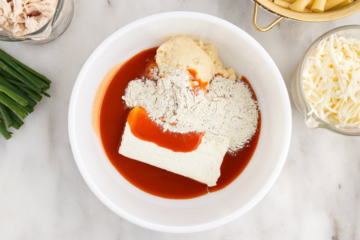 hot sauce, cream cheese, ranch seasoning mix, and cream f chicken soup in a bowl