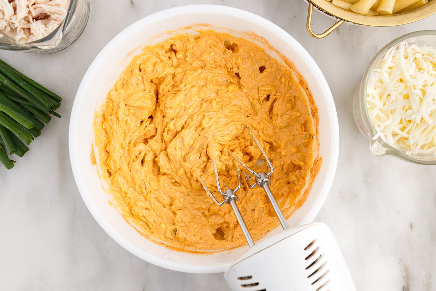 combining buffalo chicken ingredients with a mixer
