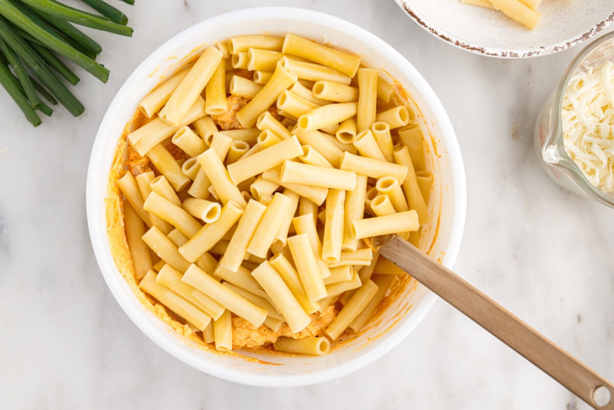 combining pasta with buffalo chicken mixture