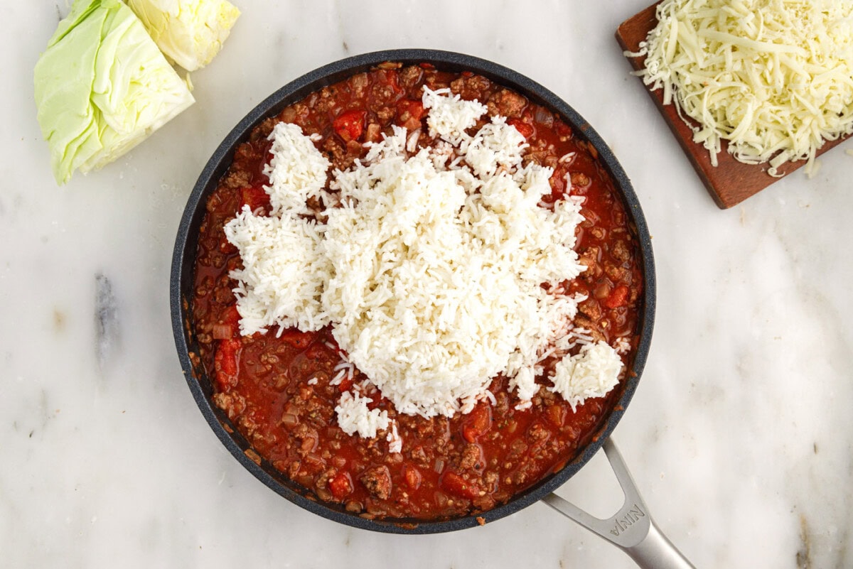 white rice added to skillet with cabbage roll filling