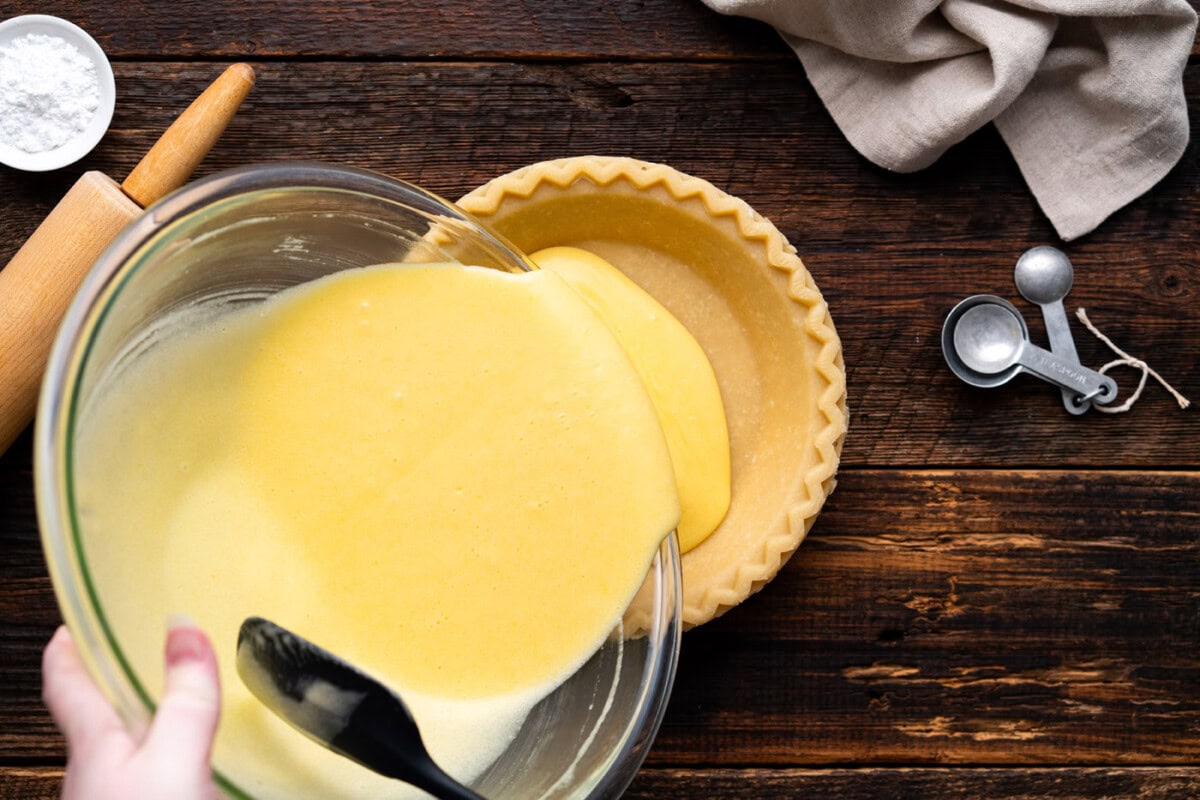 pouring chess pie filling into a pie crust
