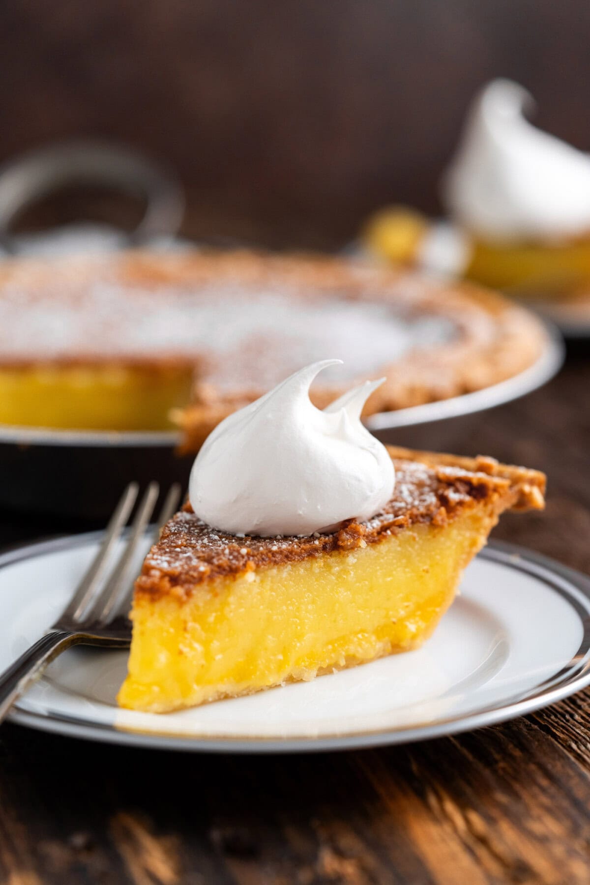 Slice of Chess Pie on a plate topped with whipped cream