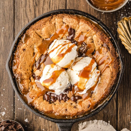 Chocolate Chip Caramel Skillet Cookie topped with ice cream and caramel