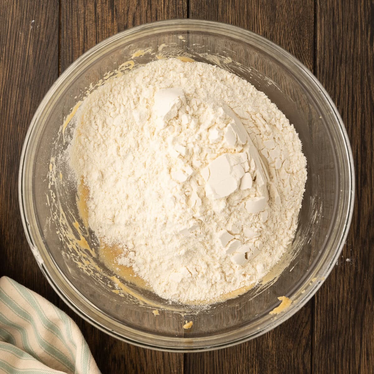 adding flour mixture to wet ingredients for cookie dough