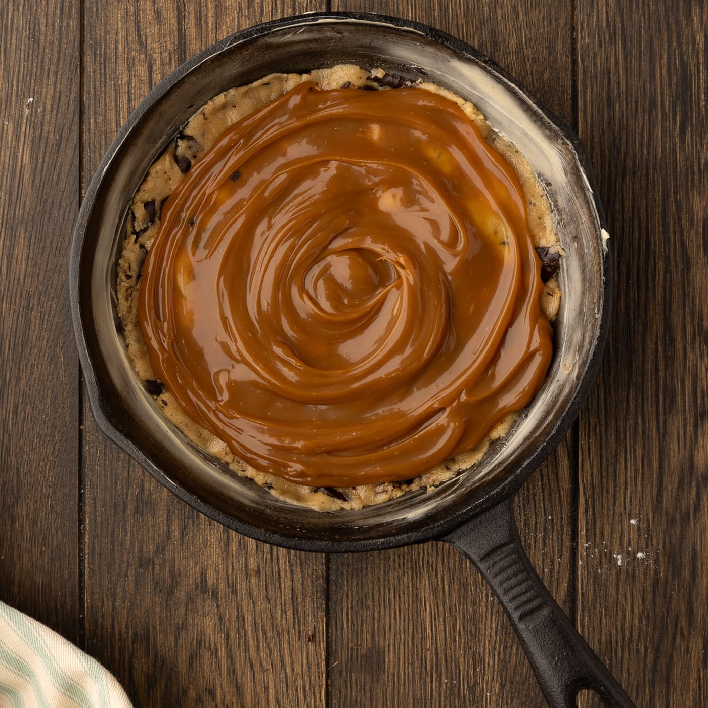 layer of salted caramel sauce over cookie dough in a skillet