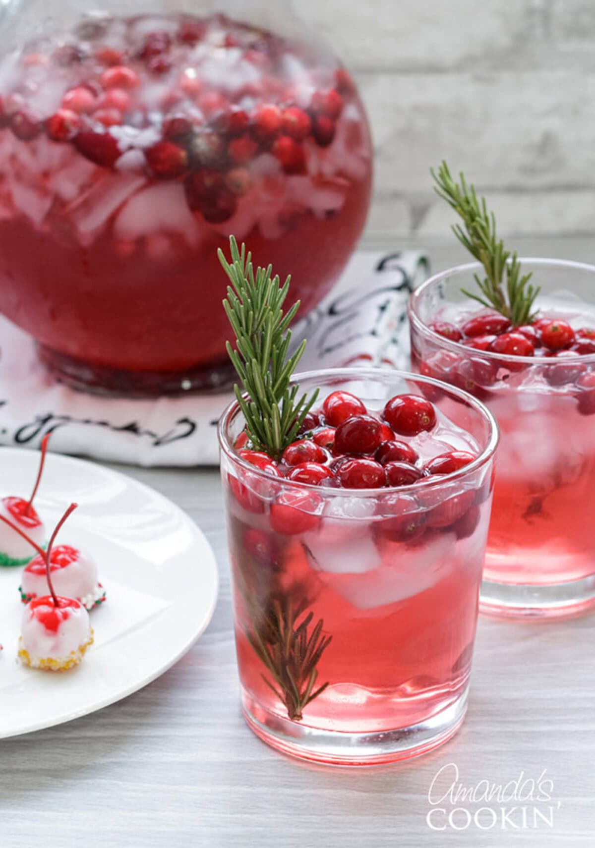 Cranberry Holiday Punch is perfect for your festive parties. Whip it up for your Thanksgiving gathering or a Christmas party! two glasses and a pitcher of holiday punch