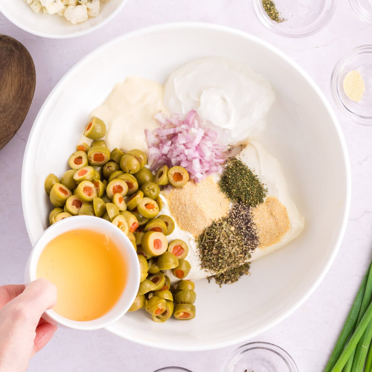 adding olive bring to sliced olives, seasonings, shallot, and cream cheese in a bowl
