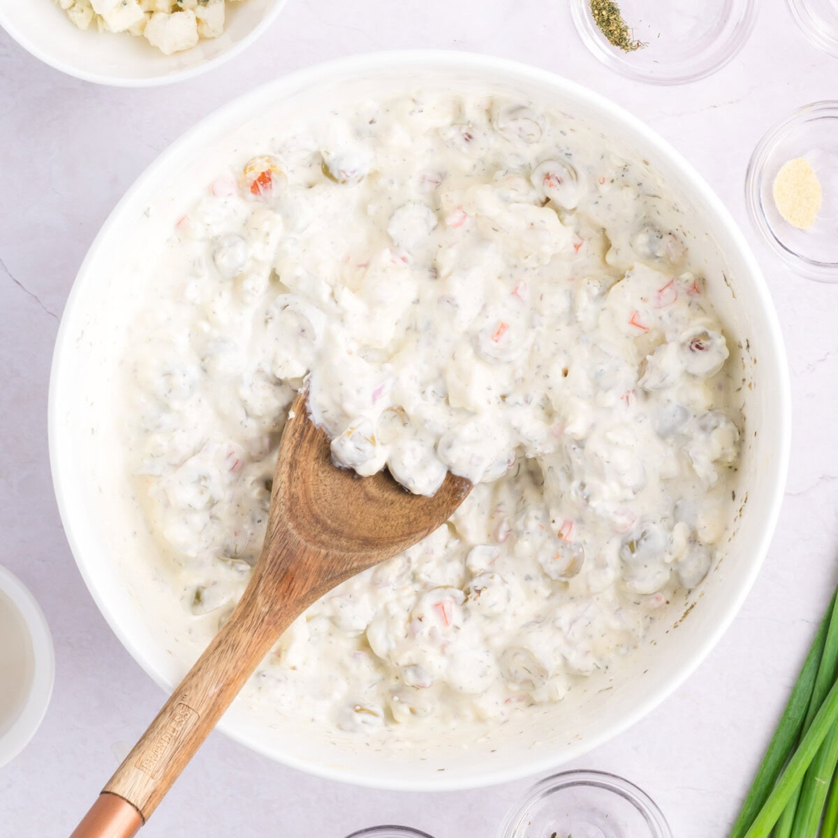 wooden spoon mixing dirty martini dip
