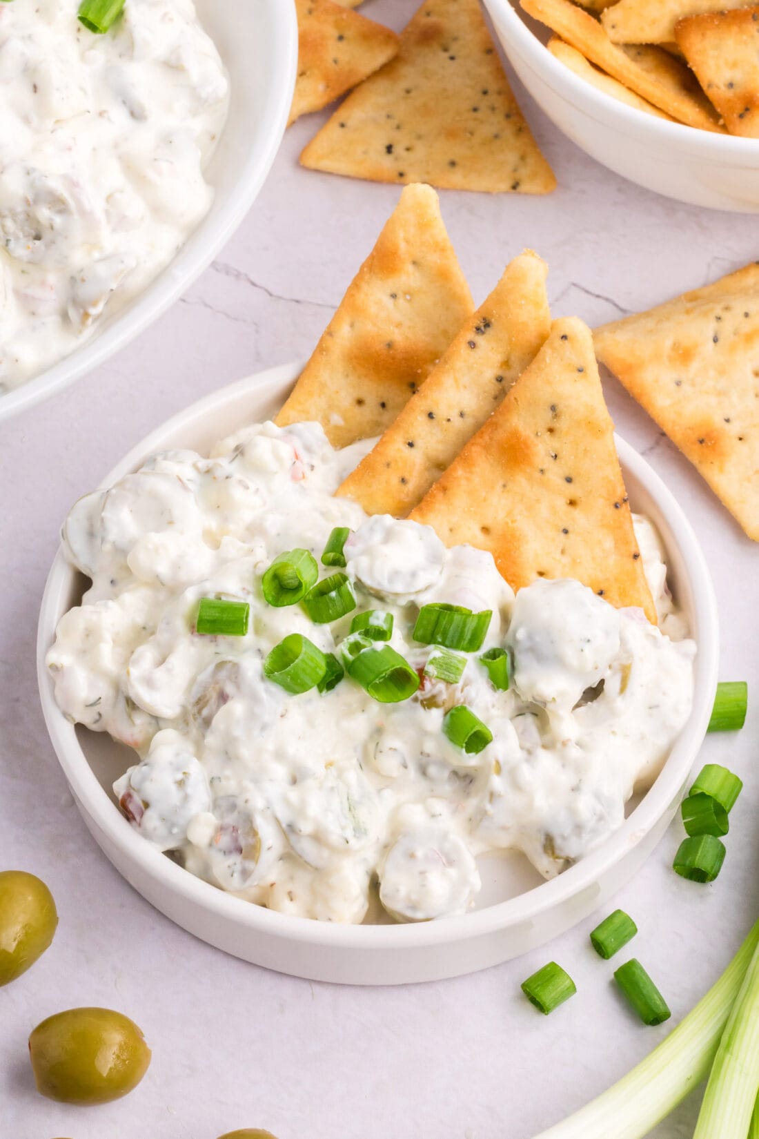 Dirty Martini Dip on a plate with crackers