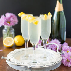 Three French 75 cocktails garnished with lemon twists