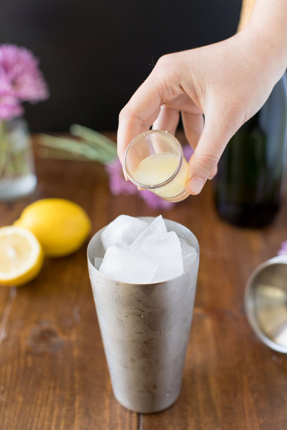 pouring lemon juice into cocktail shaker