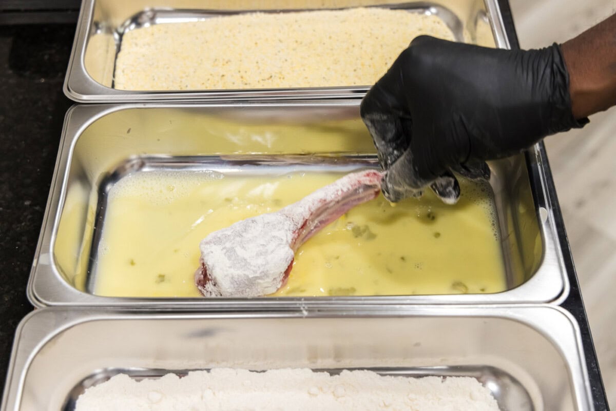 dipping lamb chop in egg mixture