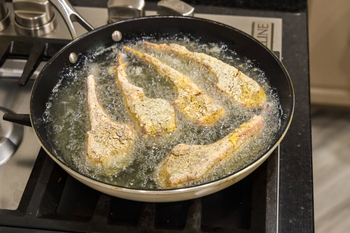 dredged lamb chops frying in oil