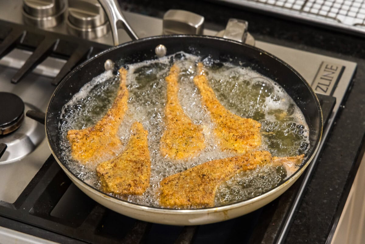 fried lamb chops in a skillet of oil
