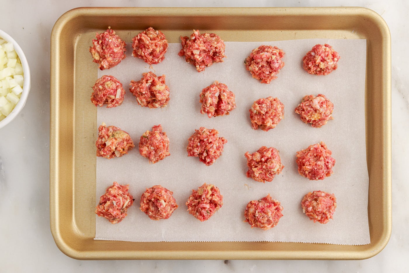Italian sausage and ground beef meatballs on a baking sheet
