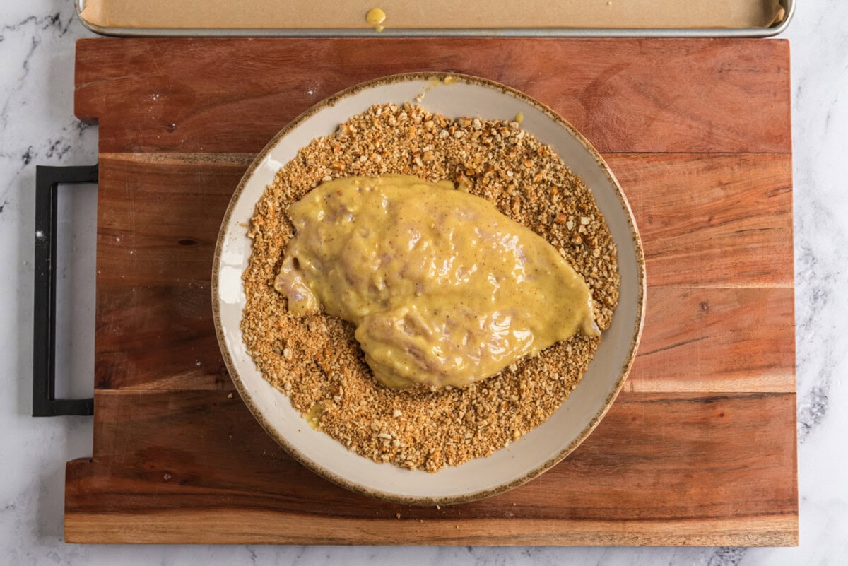 coating honey mustard chicken in crushed pretzels