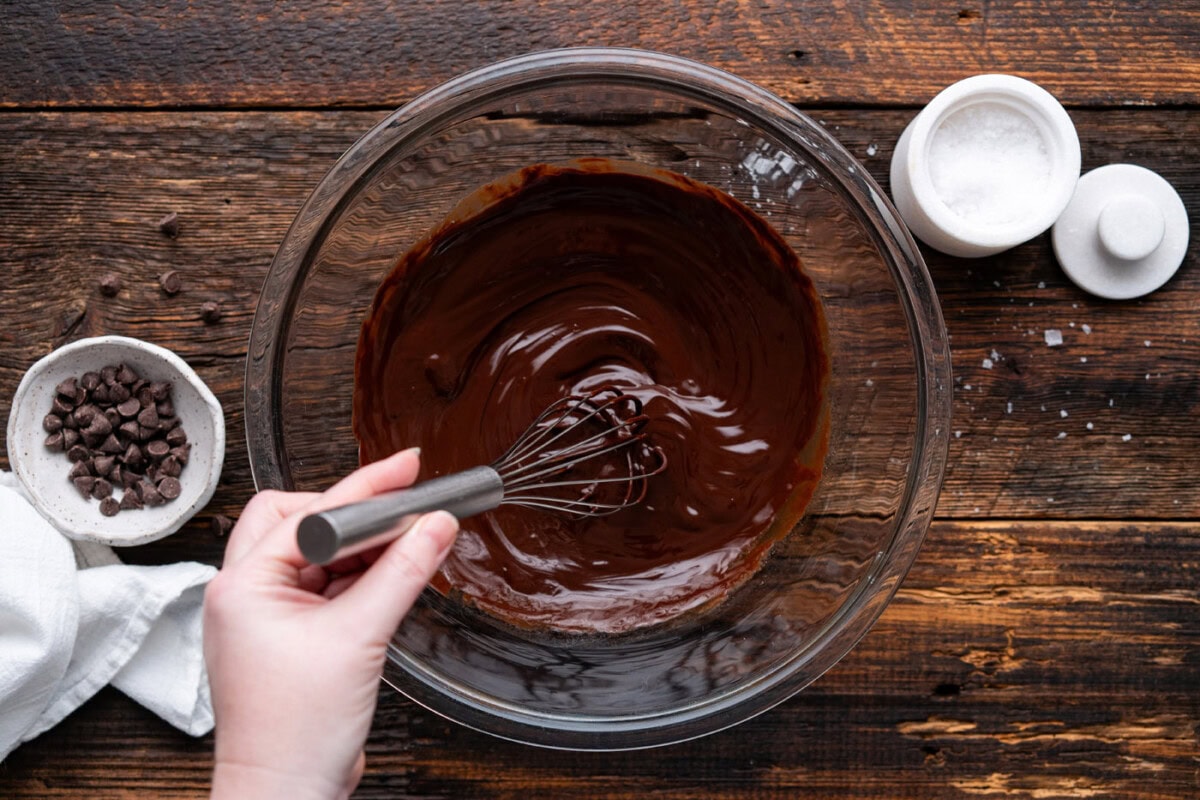 whisking together melted chocolate and butter in a bowl