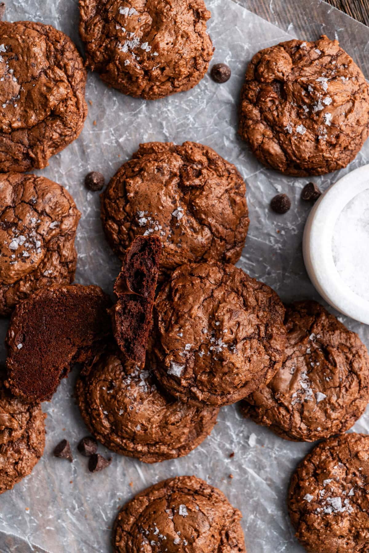 A Salted Brownie Cookie broken in half resting on more Salted Brownie Cookies