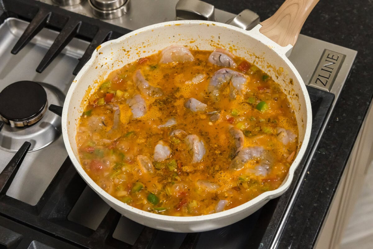 cooking shrimp into tomato sauce in a skillet