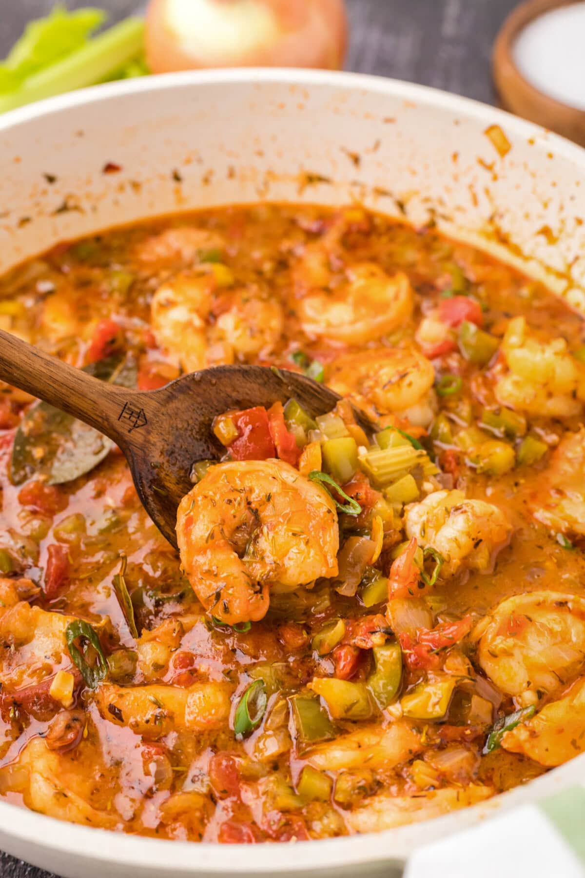 Close up photo of a spoonful of Shrimp Creole in a skillet