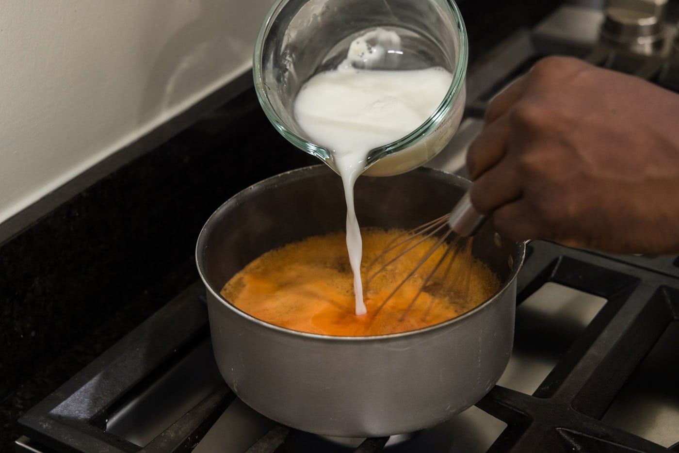 pouring cornstarch slurry into sweet and sour sauce