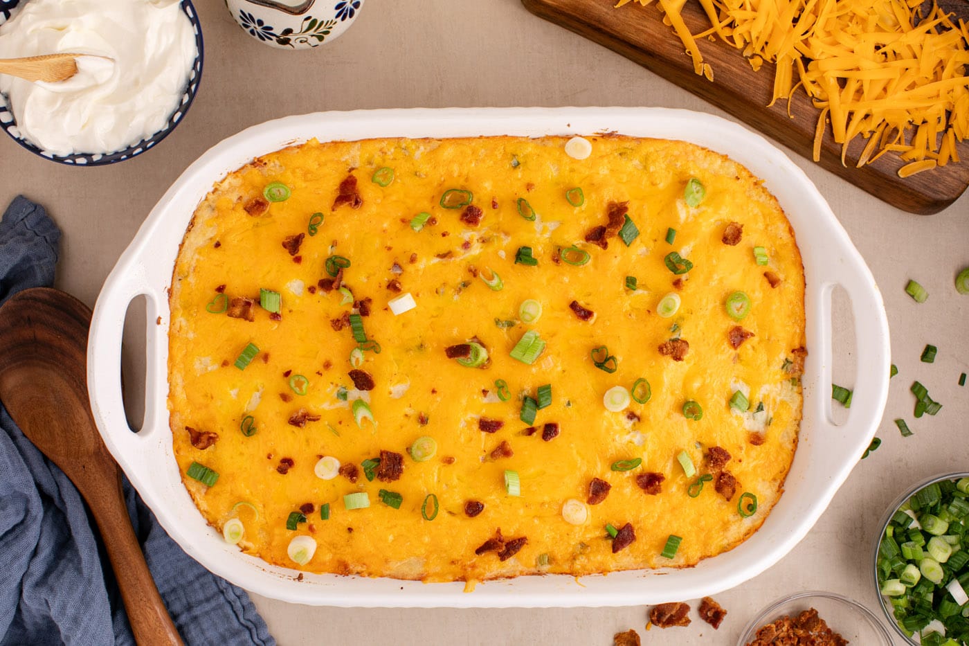 crumbled bacon and green onions on top of twice baked potato casserole