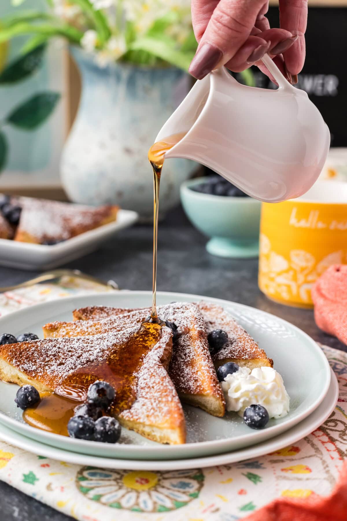 Syrup being drizzled over three slices of Air Fryer French Toast on a plate