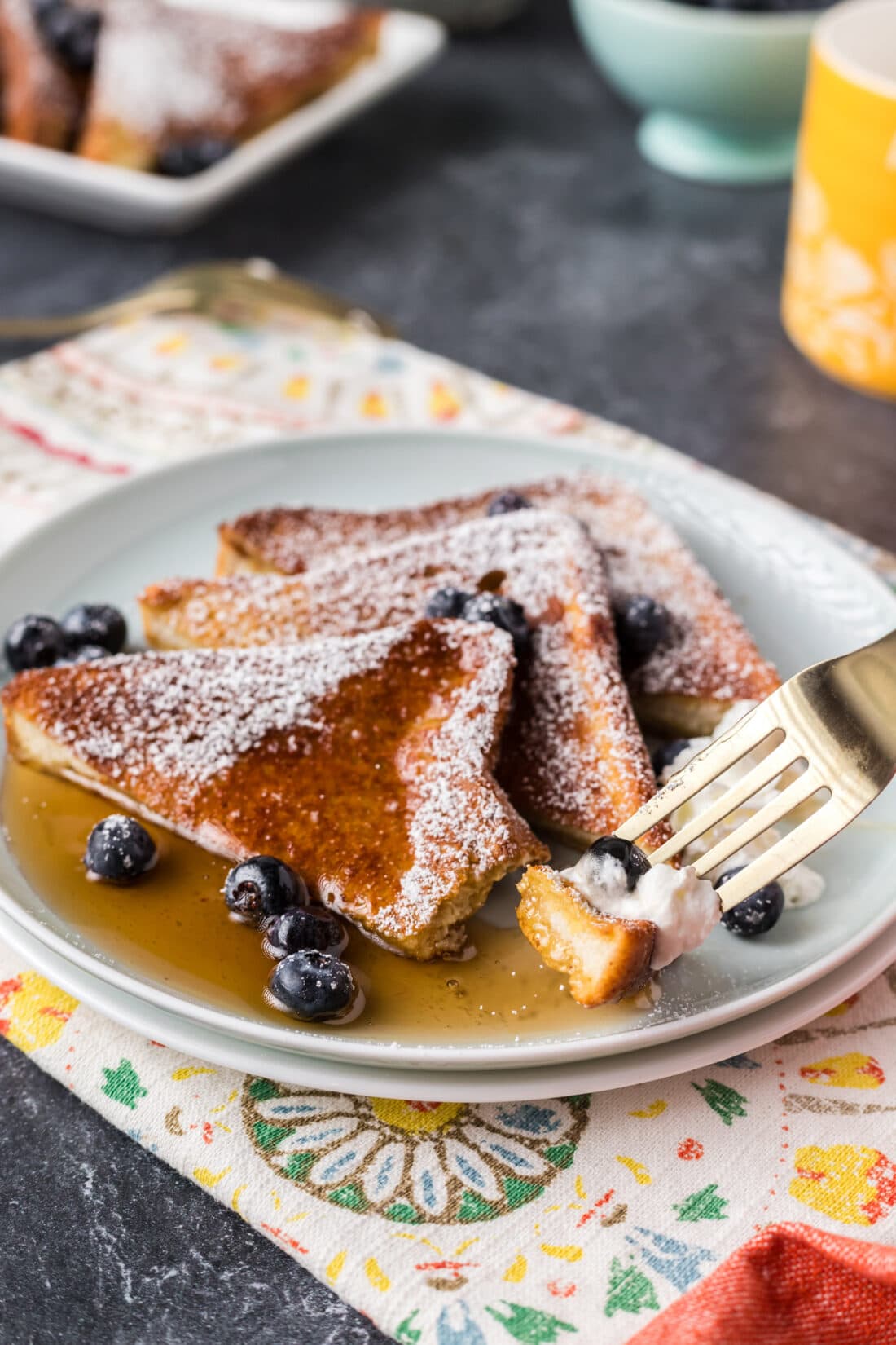 Piece of Air Fryer French Toast on a fork resting on a plate 