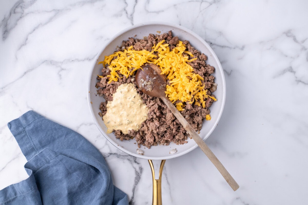 Big mac sauce and shredded cheese added to ground beef mixture in a skilet
